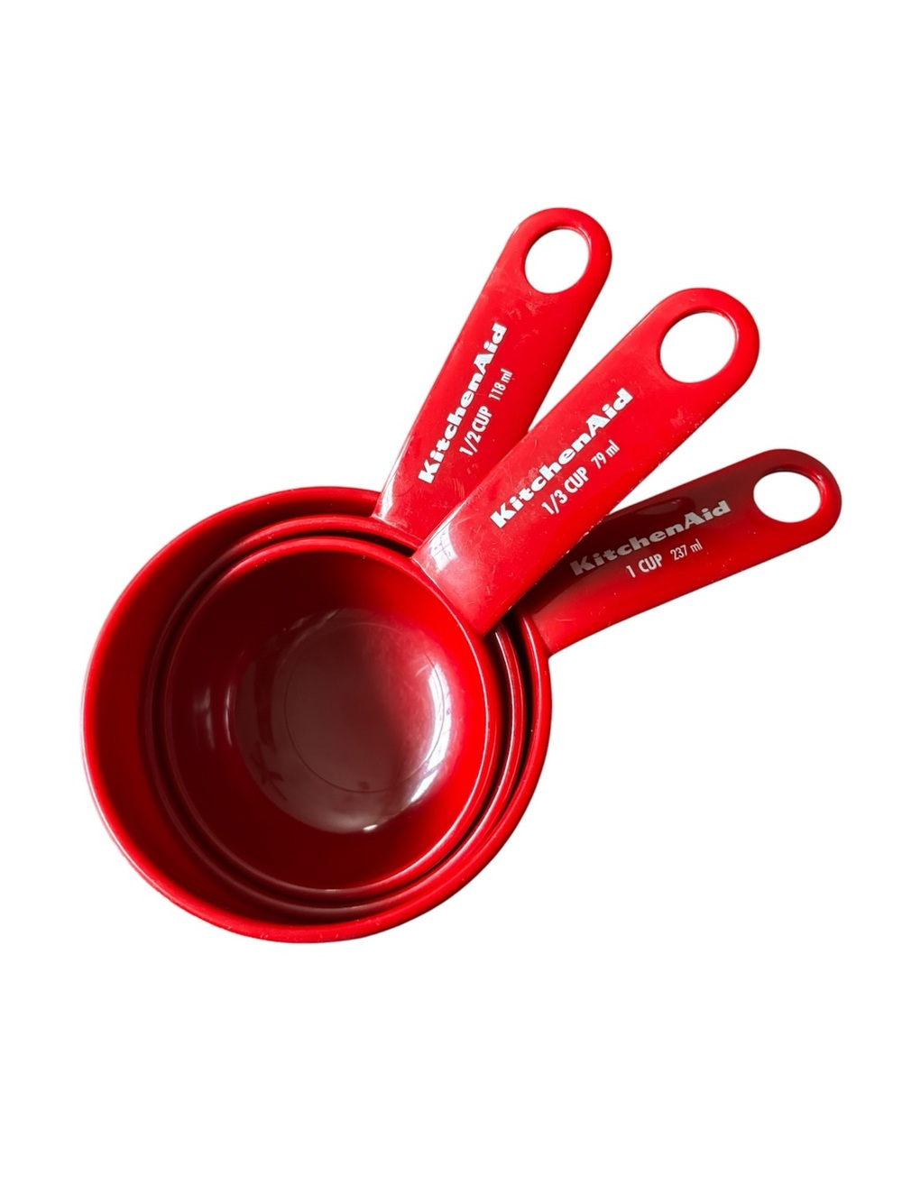 3 KitchenAid Red plastic measuring cups. 1 cup, 3/4 cup, 1/2 and 1/3 cups